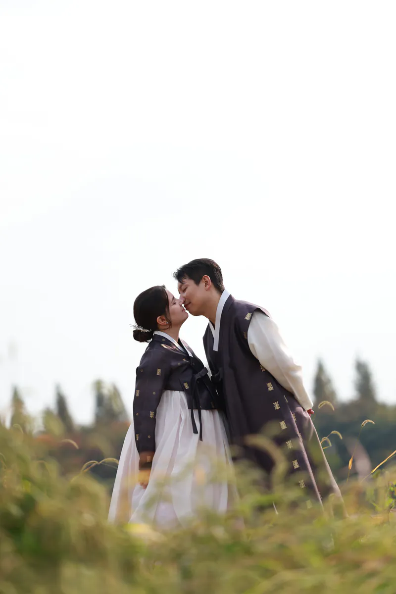 Sara e Jiwon con hanbok bicándose entre herba alta